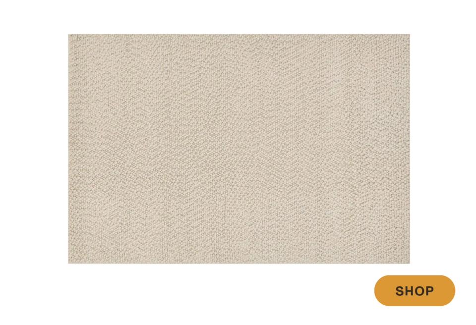 Minimalist natural fiber area rug in warm beige with subtle woven texture