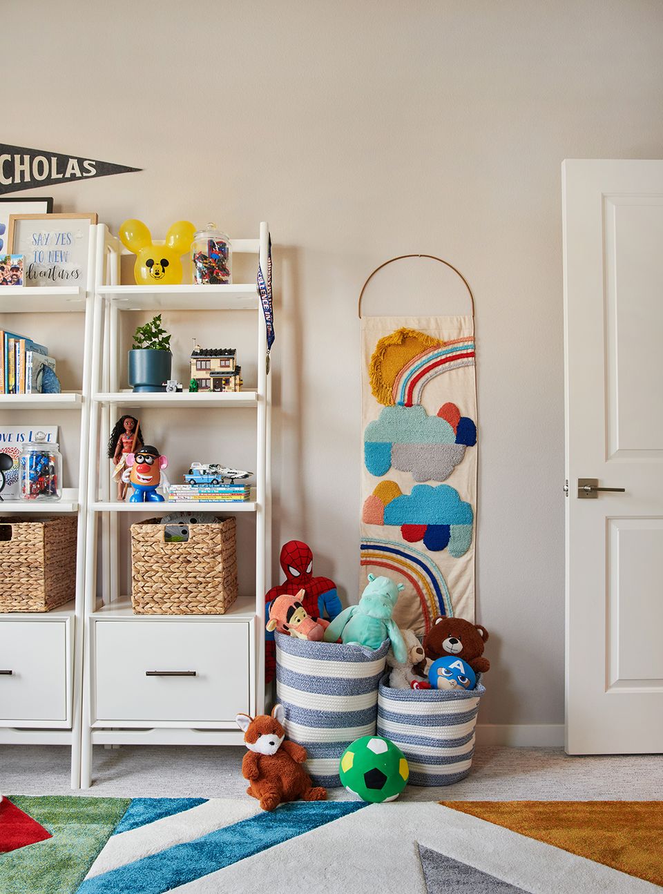 Playful kids' room with white shelving, striped baskets, and colorful wall organizer in cheerful, accessible layout.