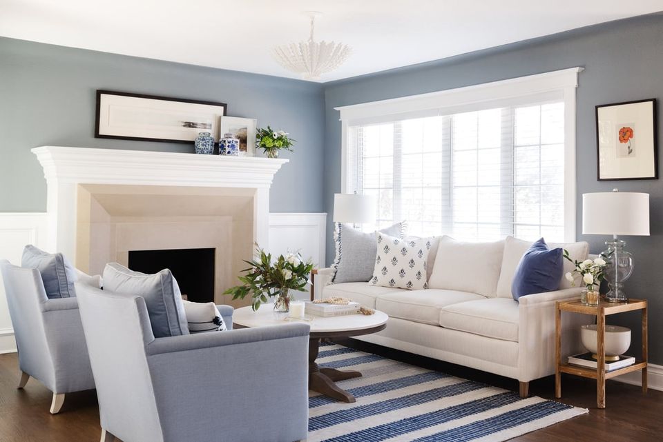 Serene coastal living room with blue-gray walls, cream sleeper sofa, and light-filled modern farmhouse aesthetic