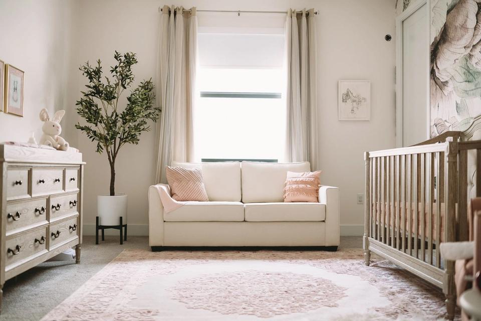 Serene neutral nursery with cream sofa, soft pink accents, botanical elements, and natural light