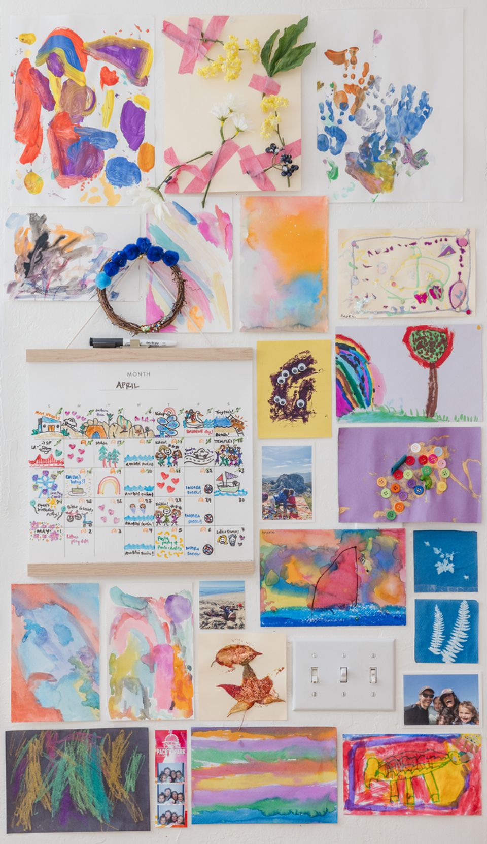 Vibrant gallery wall of colorful children's artwork creating playful, expressive dining space