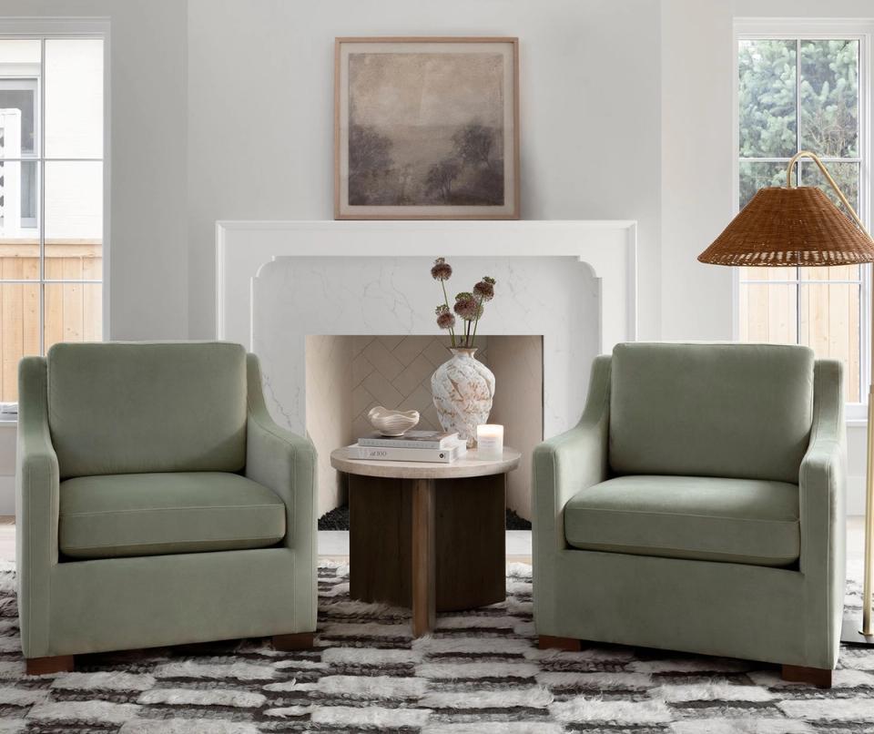 Serene living room with sage green armchairs, neutral palette, and mid-century modern aesthetic