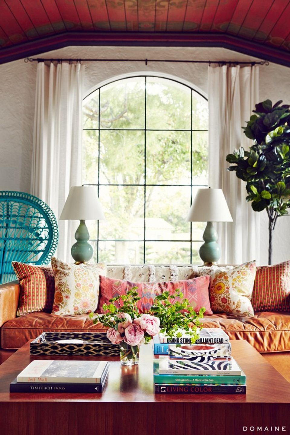 Eclectic window nook with burgundy ceiling, colorful pillows, and maximalist bohemian style