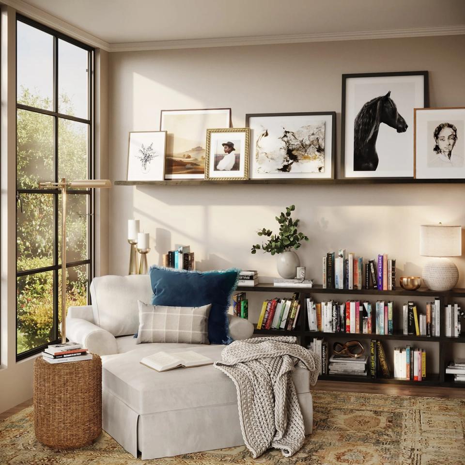 Bright, airy reading nook with coastal palette: cream chair, blue accent pillow, natural wood shelving, and gallery wall.