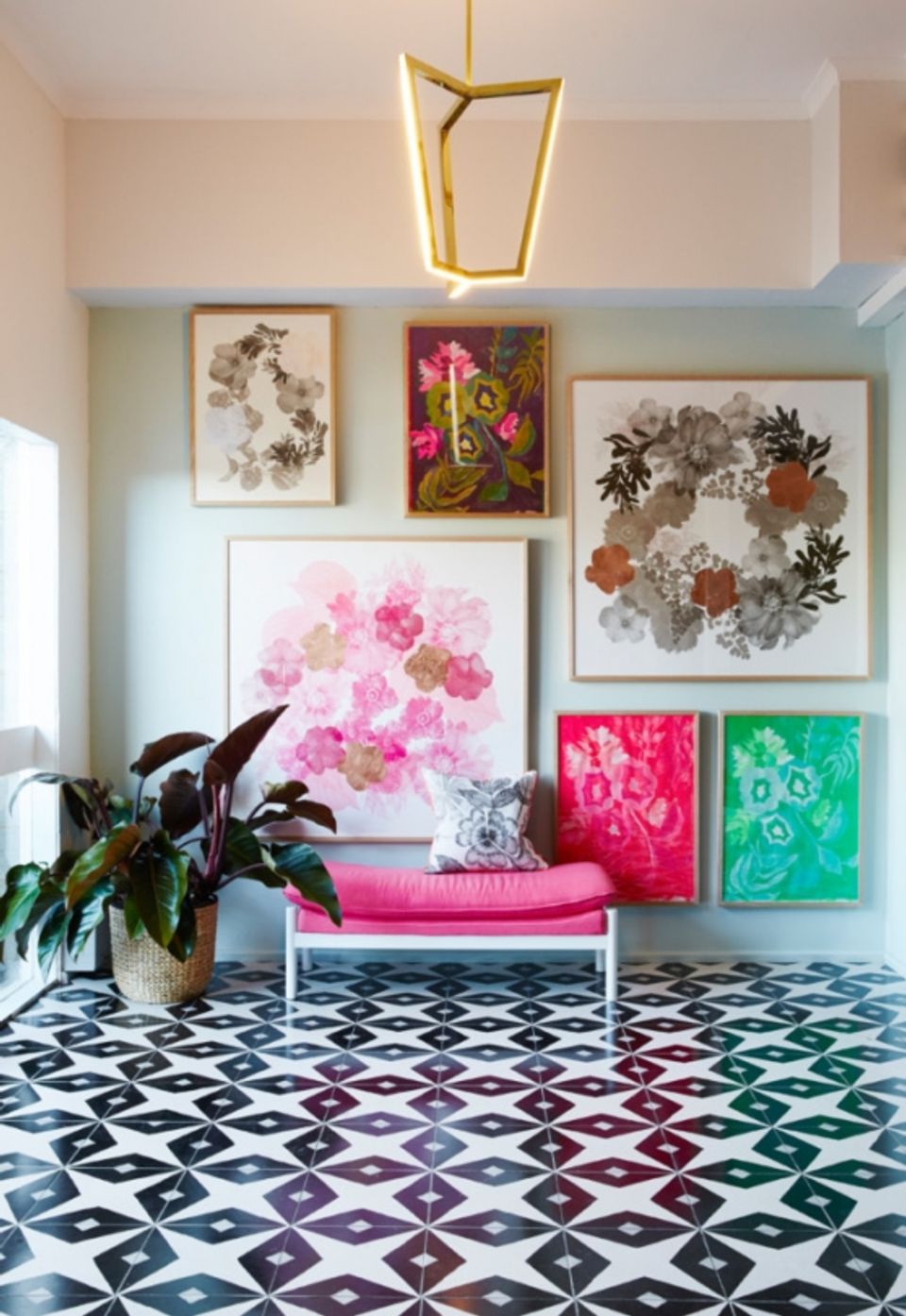 Modern eclectic gallery wall featuring pink floral artwork and botanical prints
