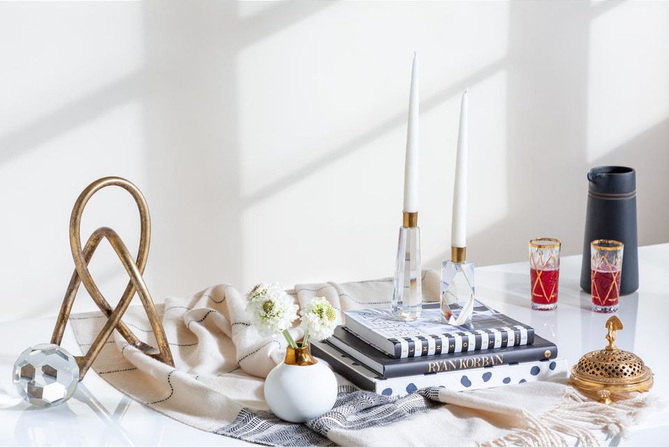 Modern minimalist styling with natural wood accents, white ceramics, and gold metallic details arranged on a clean white surface