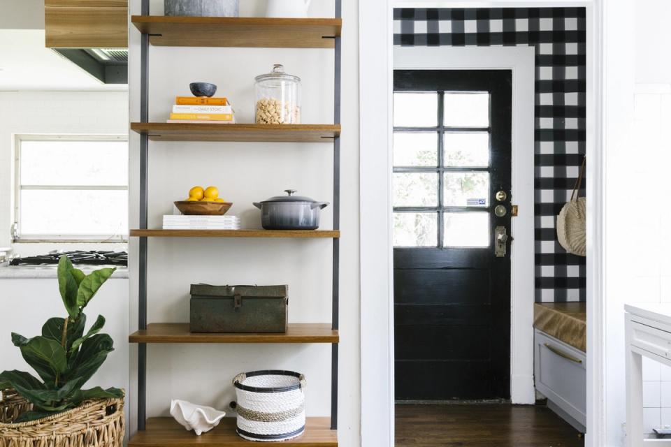 Scandinavian pantry with open shelving, natural wood frames, white walls, and organized storage containers in a bright, minimalist space