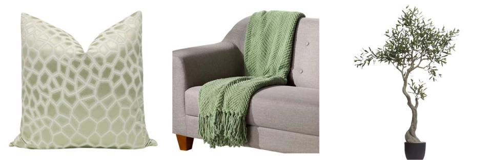 Sage green accents including geometric pillow, draped throw, and potted plant for organic styling.