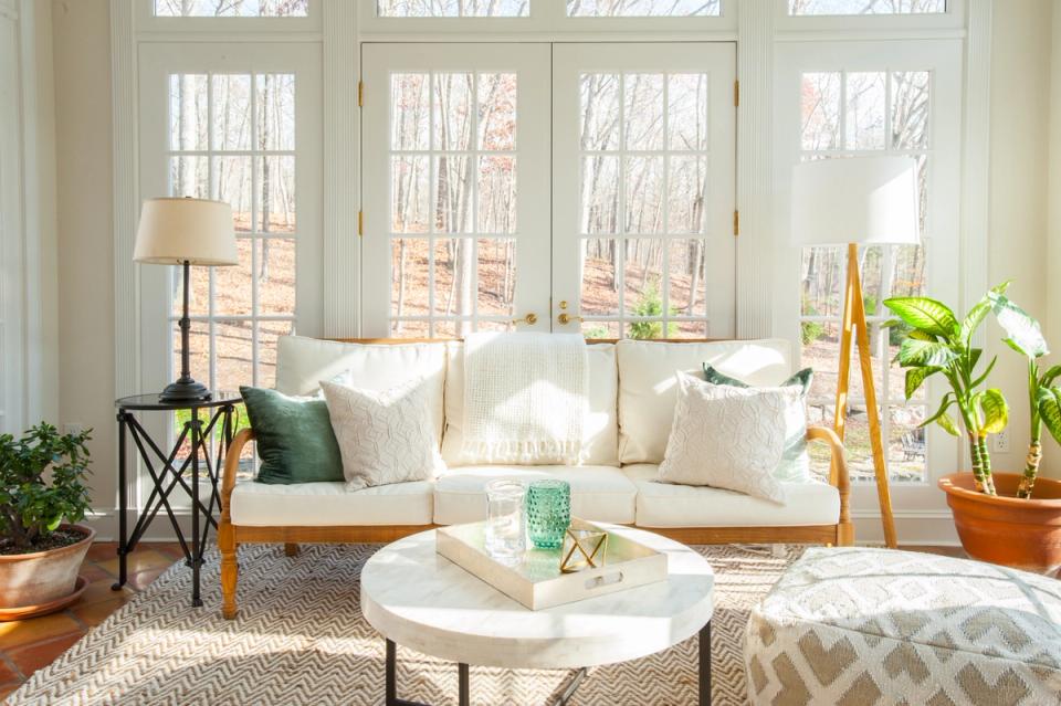 Serene coastal living room with cream sofa, natural wood tones, and abundant natural light
