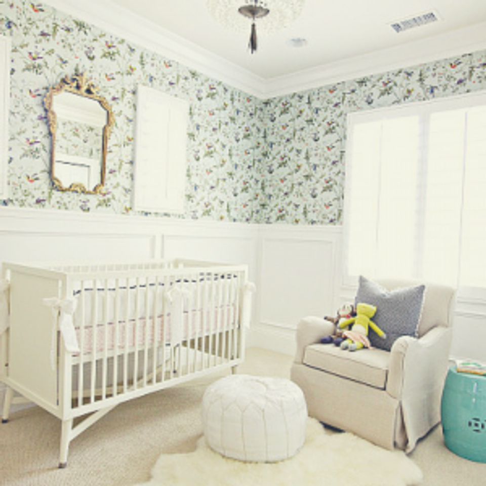 Soft nursery with floral wallpaper, cream sheepskin accent, and serene pastel tones throughout