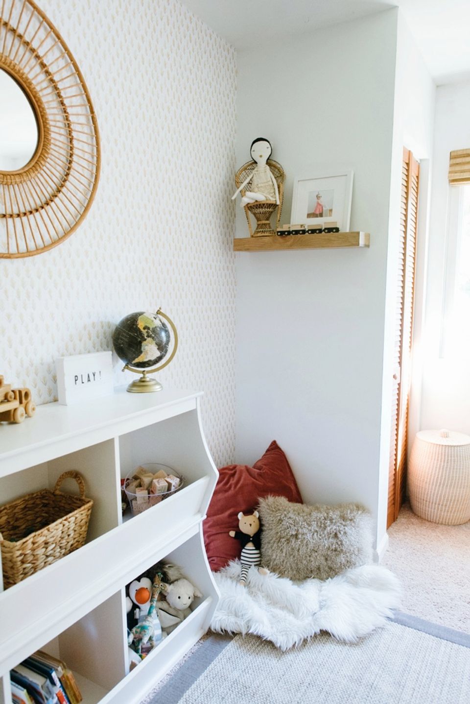 Calm Scandinavian nook with soft whites, natural textures, burgundy accents, and woven wall decor