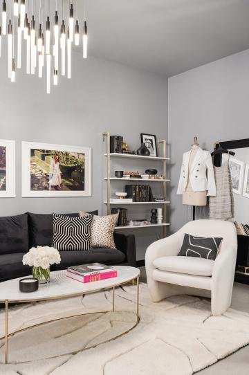 Elegant dressing room blending black sofa, cream chair, geometric patterns, and statement lighting