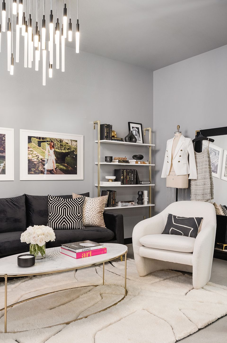 Elegant dressing room blending black sofa, cream chair, geometric patterns, and statement lighting