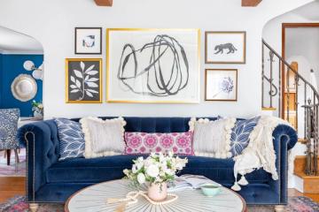 Modern bohemian living room with navy velvet sofa, eclectic gallery wall, and warm wood accents
