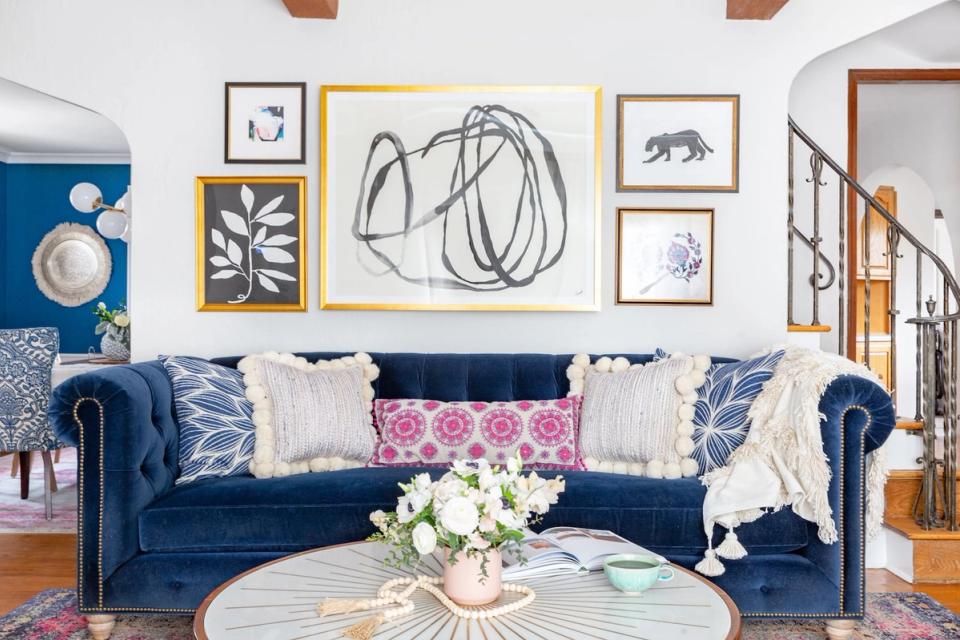 Modern bohemian living room with navy velvet sofa, eclectic gallery wall, and warm wood accents