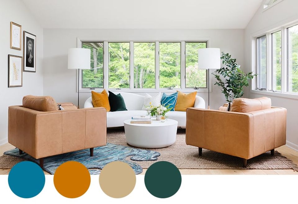 Modern sunlit living room with warm cognac leather seating, teal accents, and mustard touches against neutral backdrop.