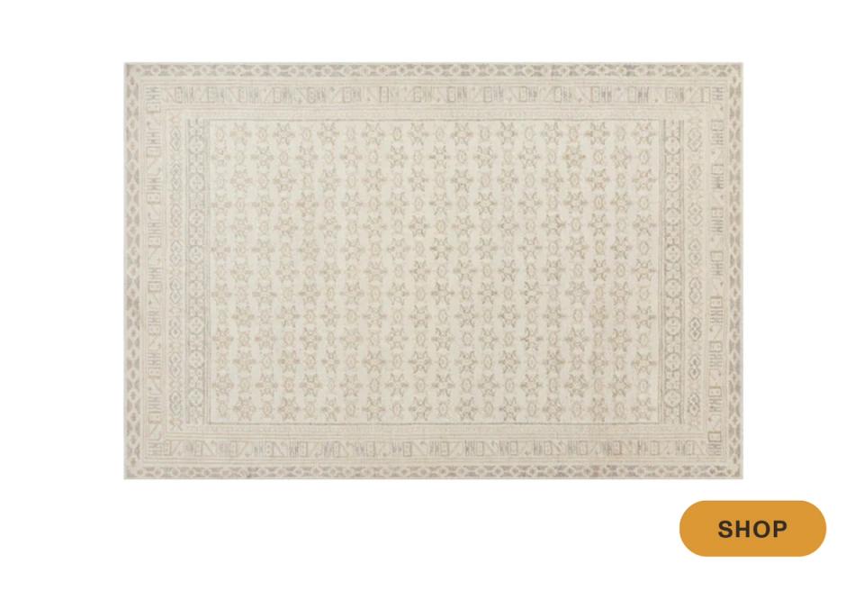 Neutral textured area rug with subtle geometric border in cream and beige tones