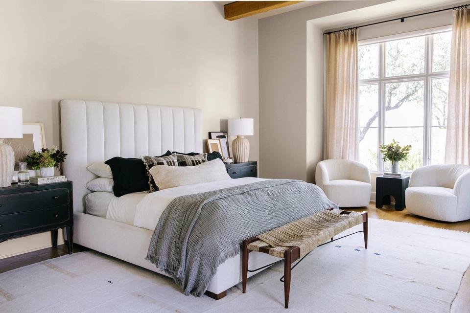 Serene greige bedroom with white channel bed, soft furnishings, and minimalist aesthetic