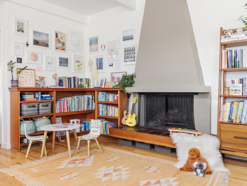 Contemporary family room blending mid-century wood storage, playful accents, and modern fireplace