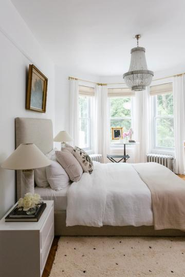 Elegant transitional bedroom with neutral palette, crystal chandelier, and classic proportions