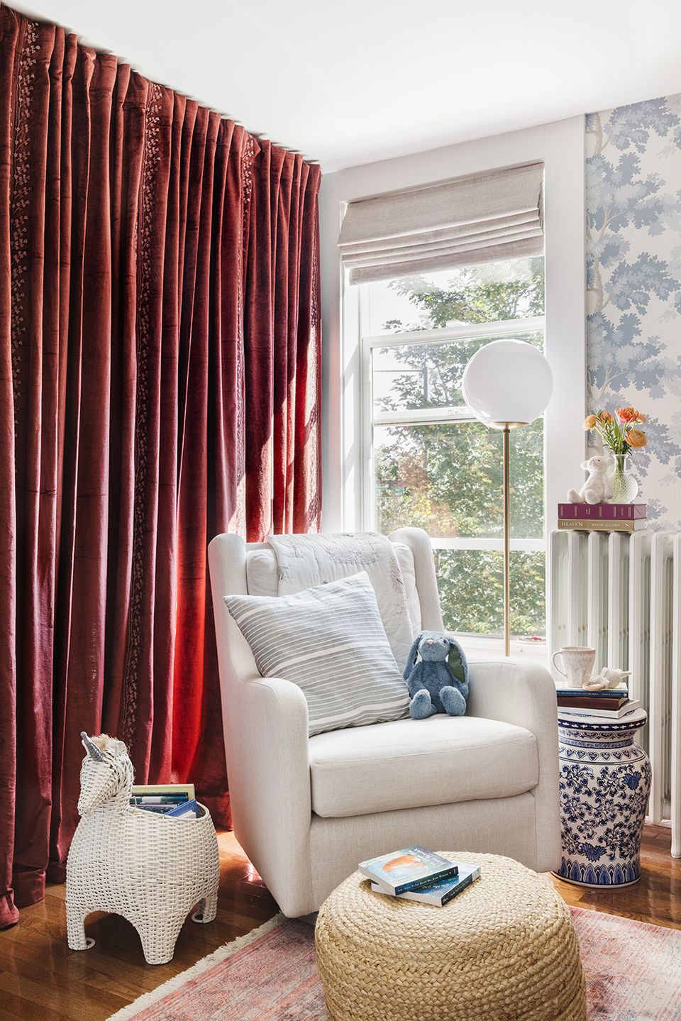 Eclectic sitting area with rich burgundy velvet drapes and cream upholstered chair