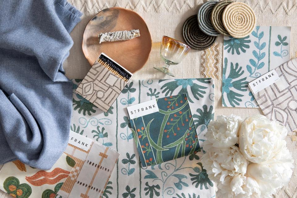 Flat lay of St. Frank fabrics and accessories in blue, green, and cream botanical patterns