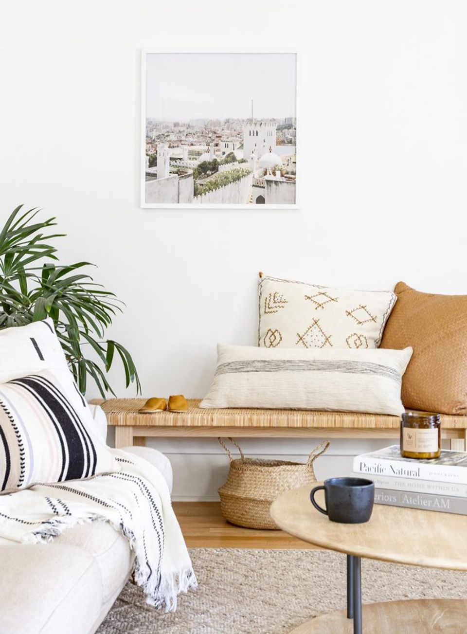 Coastal modern corner with natural wood bench, geometric pillows, and botanical details
