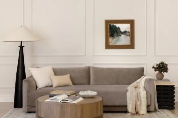 Minimalist living room with gray sofa, wooden coffee table, wainscoting, and muted earth-tone accessories