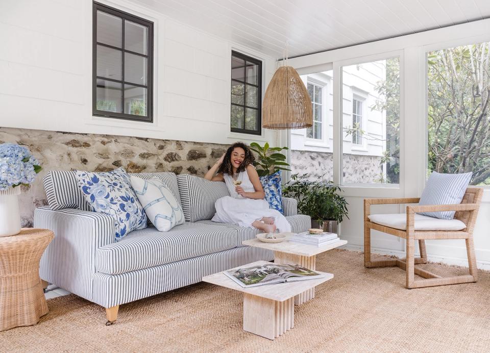 Serene coastal living room with blue-striped upholstery, natural wood frames, and soft neutral tones throughout.