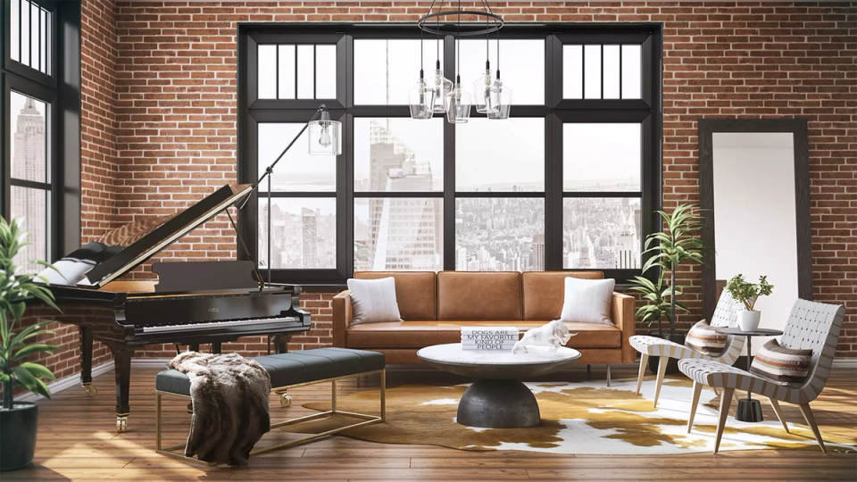 Eclectic brick loft living room with caramel sofa, grand piano, and abundant natural light
