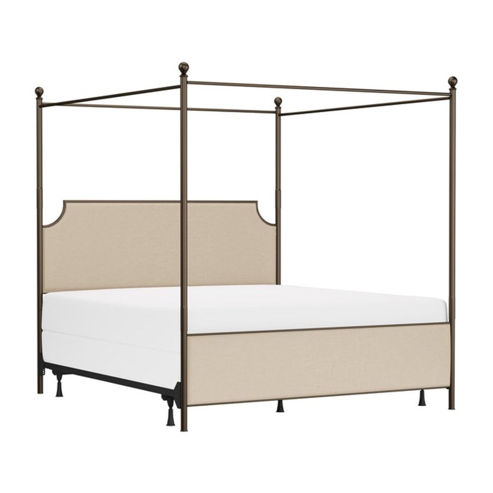 Traditional canopy bed with bronze metal frame and neutral beige upholstered panels