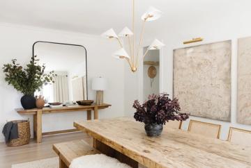 Scandinavian dining space with light wood table, brass pendant fixture, and minimalist aesthetic