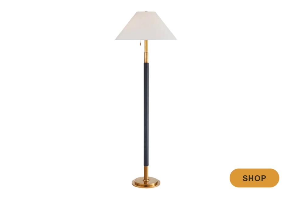 Contemporary floor lamp with cream shade, black stem, and brass base in warm metallics