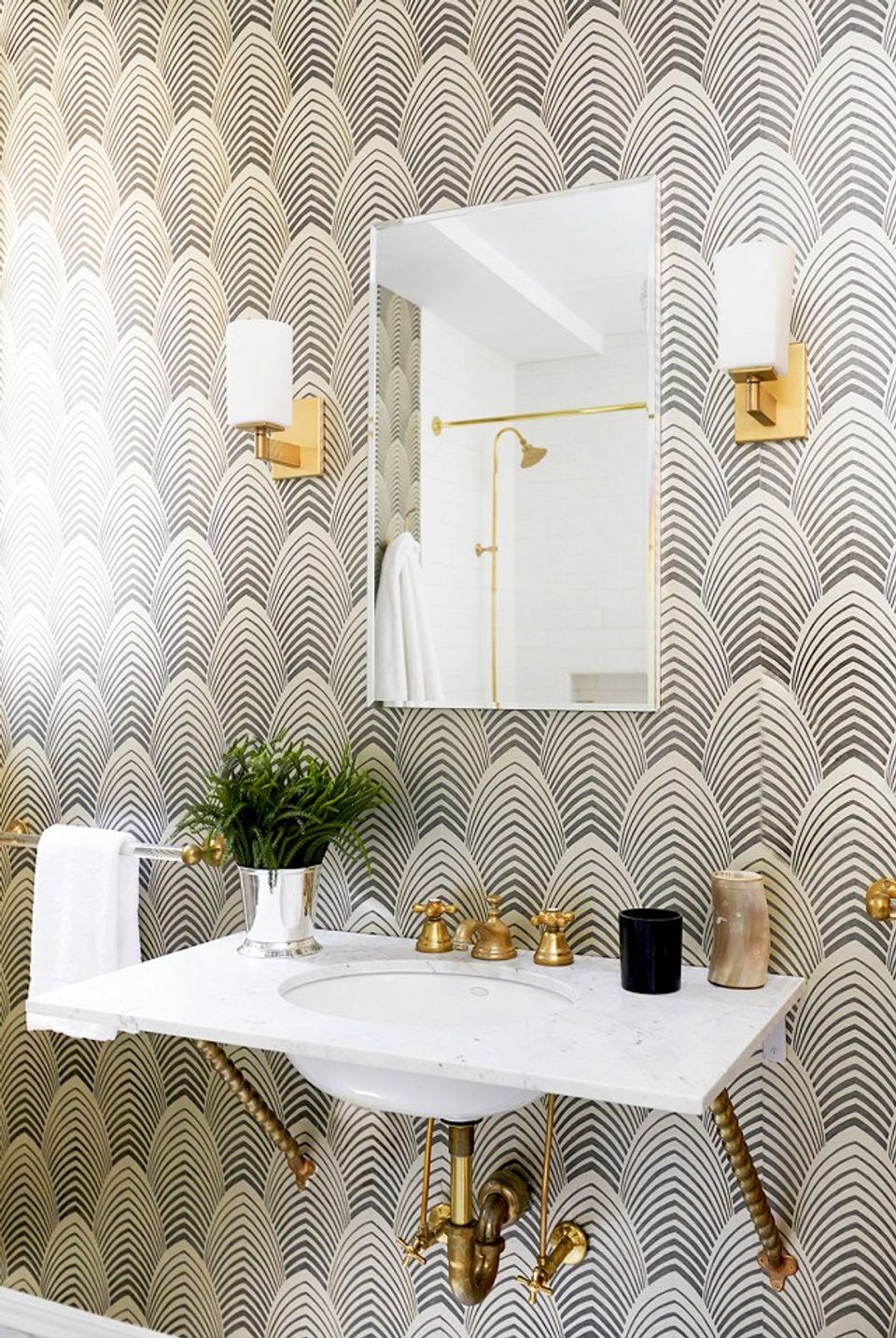 Bold geometric patterned bathroom with white fixtures, gold hardware, and minimalist styling