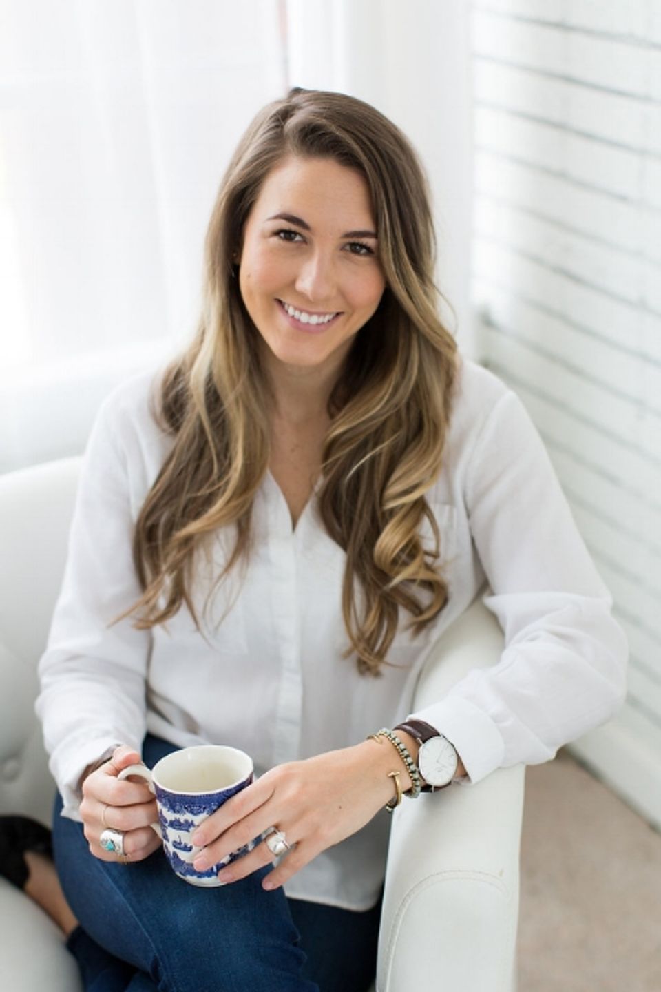 Wellness counselor in bright, minimalist space with natural light and calming white palette