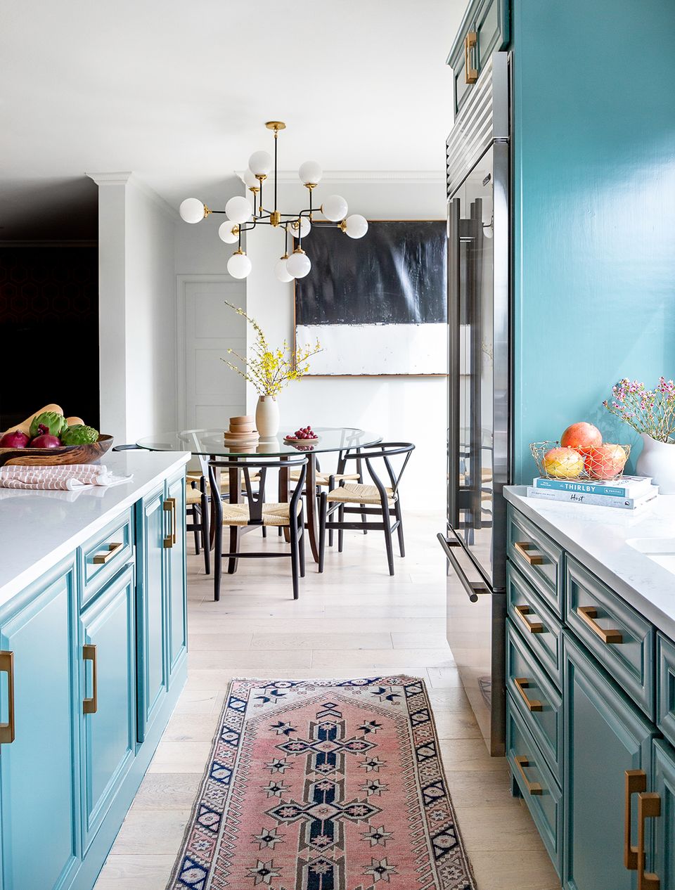 Transitional kitchen with turquoise cabinetry, brass fixtures, and eclectic style.