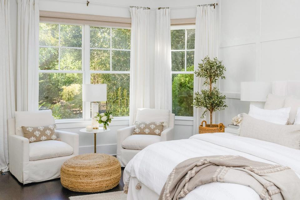 Airy bedroom with expansive windows, light furnishings, and natural woven accents