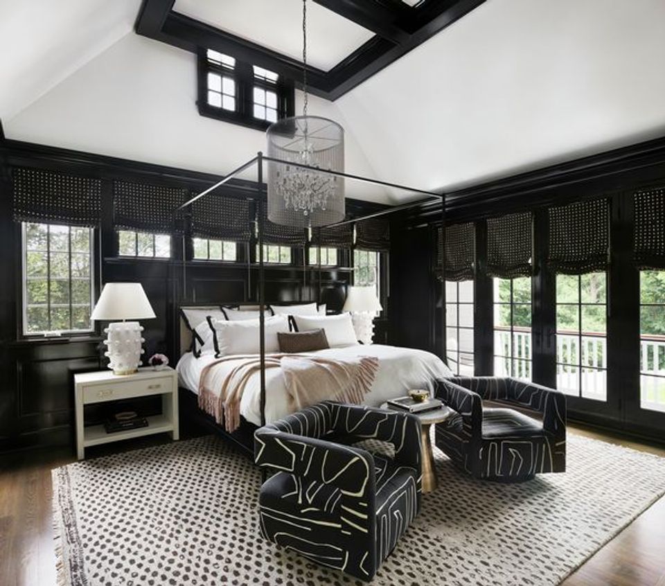 Contemporary bedroom with black paneling, patterned bedding, gold frame bed, bold geometric patterns throughout