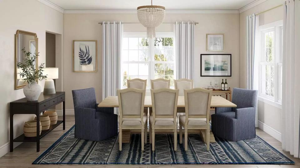Classic coastal dining room with cream walls, navy accent chairs, striped rug, and chandelier lighting