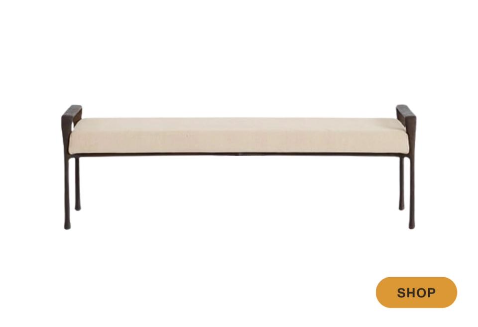 Industrial-modern bench combining cream upholstery with dark metal frame legs