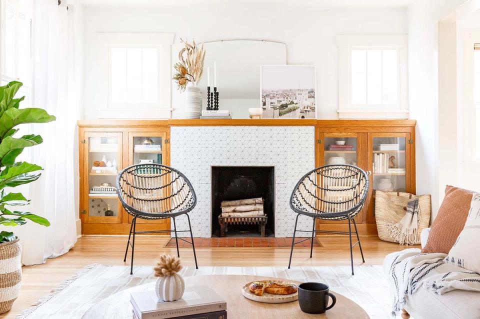 Mid-century modern living room with warm wood cabinetry, black metal chairs, and minimalist aesthetic balanced with natural greenery