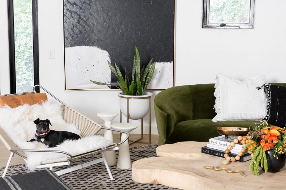 Minimalist bedroom with navy nightstand, cream bedding, and chartreuse flower accent.