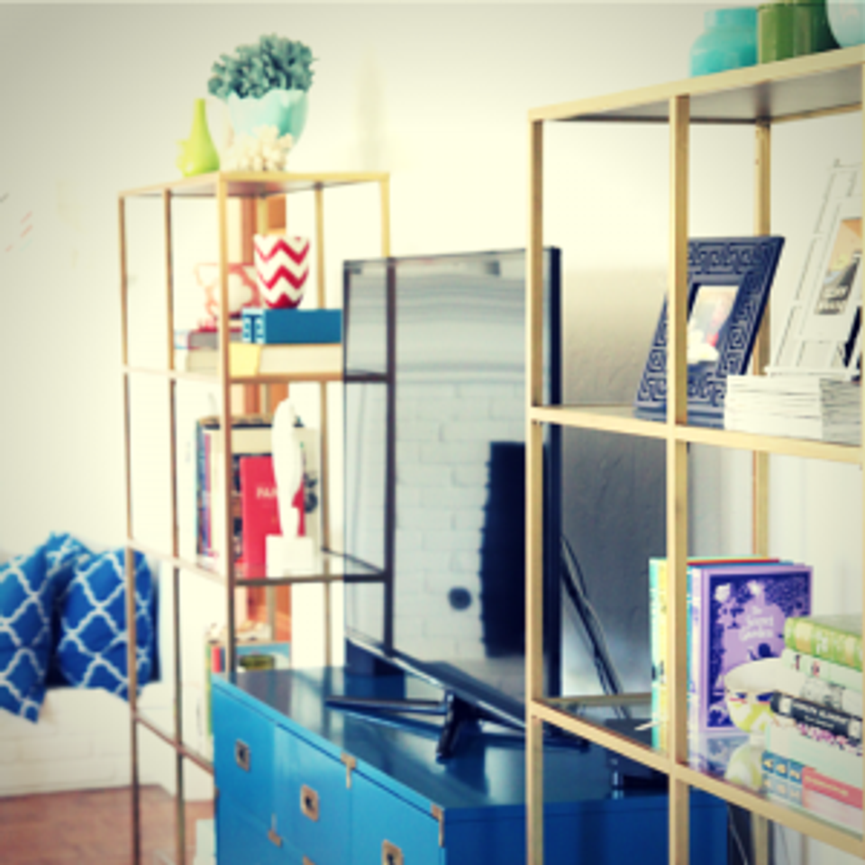 Modern eclectic campaign dresser with colorful accessories and open shelving in mixed metals
