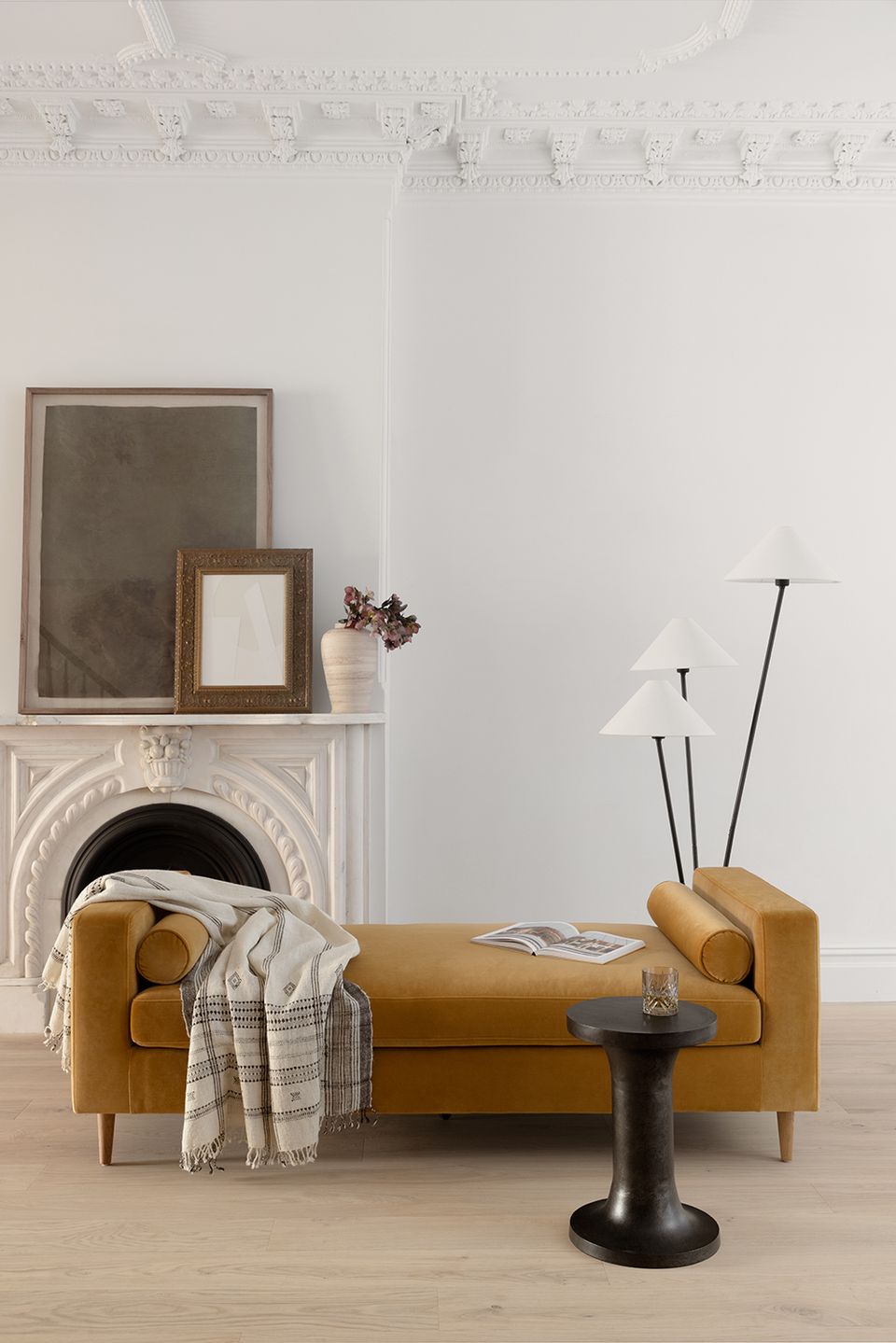 Warm caramel leather daybed with rolled arms in minimalist gallery-style room setting.