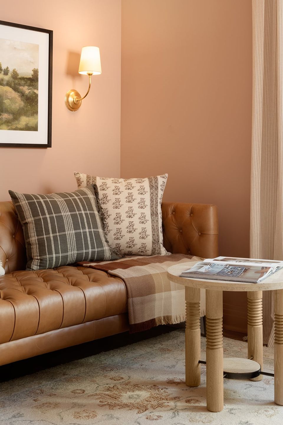 Intimate cottage nook with warm rose walls, tan leather seating, and patterned pillows