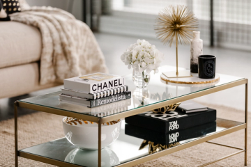 Luxe modern living room with glass and brass coffee table, neutral palette, and curated styling with fashion books and gold accents