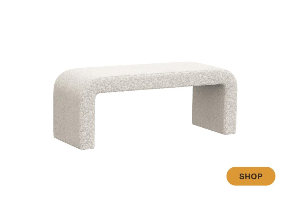 Minimalist cream boucle bench with curved architectural silhouette and open frame design