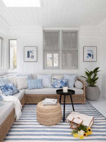 Serene nautical nook with white shiplap, blue accents, rattan poufs, and coastal-inspired artwork