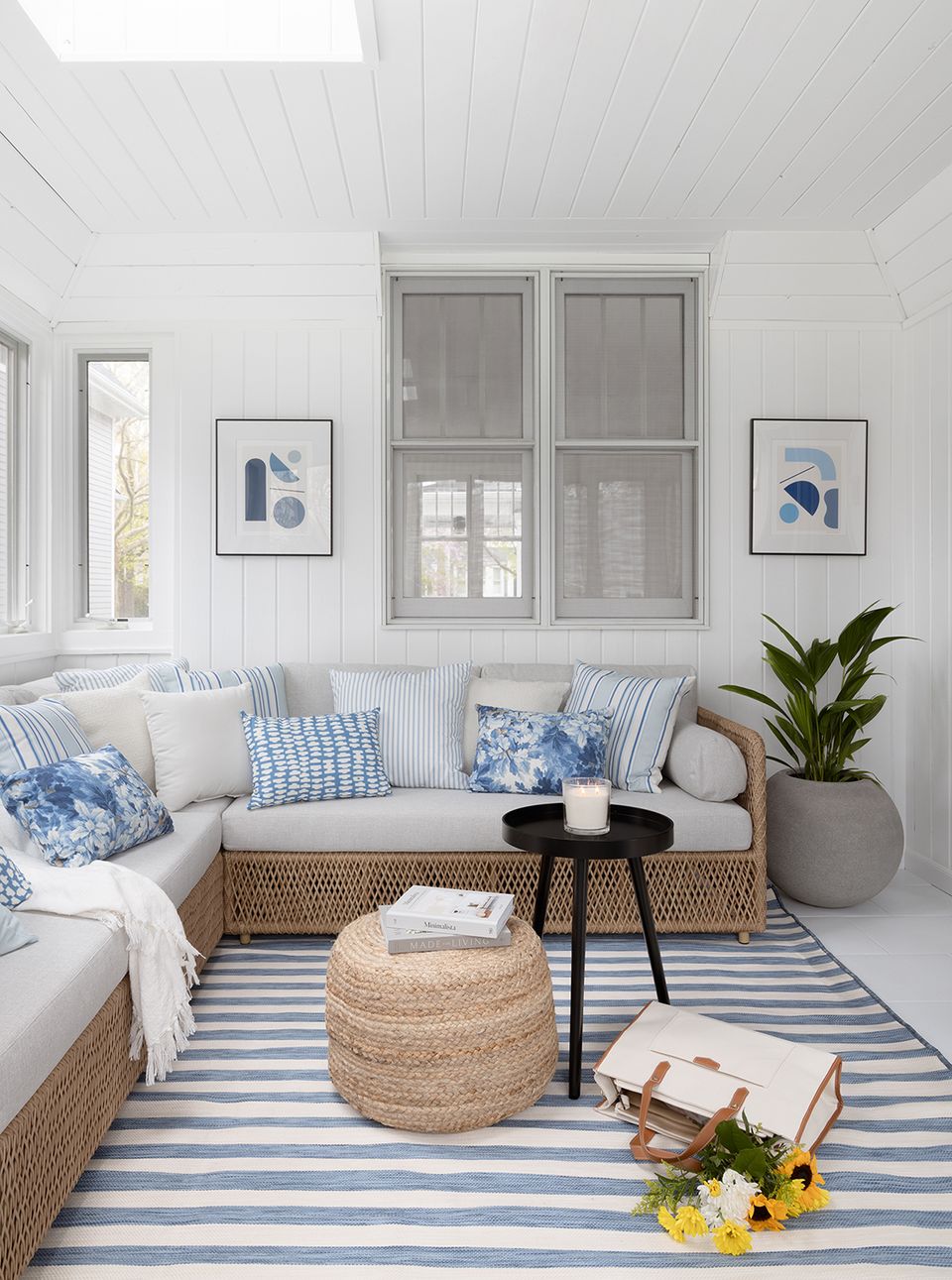 Serene nautical nook with white shiplap, blue accents, rattan poufs, and coastal-inspired artwork