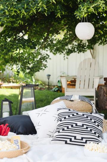 Relaxed boho backyard retreat with layered black and white textiles and soft lighting